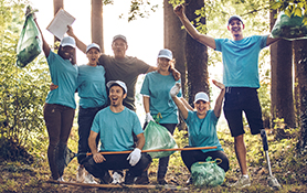 Um grupo de Leões comemorando durante um projeto de serviço na floresta.