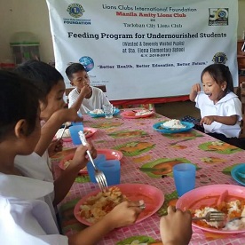 As crianças se reúnem em volta da mesa de jantar, enchendo suas barrigas com uma refeição nutritiva.